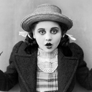 circa 1915:  American actor Bebe Daniels holds up her hands and opens her mouth in surprise, in a still from an unidentified silent film. She wears a straw hat and fingerless gloves with her hair in pigtails.  (Photo by American Stock/Getty Images)